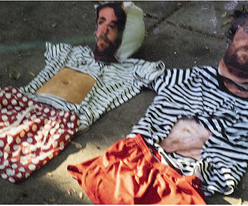 This is a picture of two simulated bodies with photo faces and clothes laid out on the ground by Richard Haley